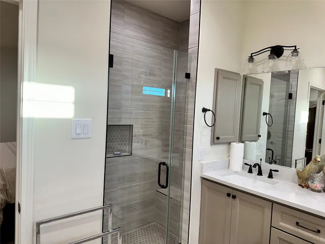 a bathroom with a granite countertop sink and a mirror