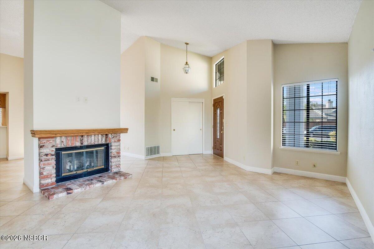 933 Bellflower Lane Lompoc, CA 93436 - Photo 3 of 17 an empty room with fireplace and windows