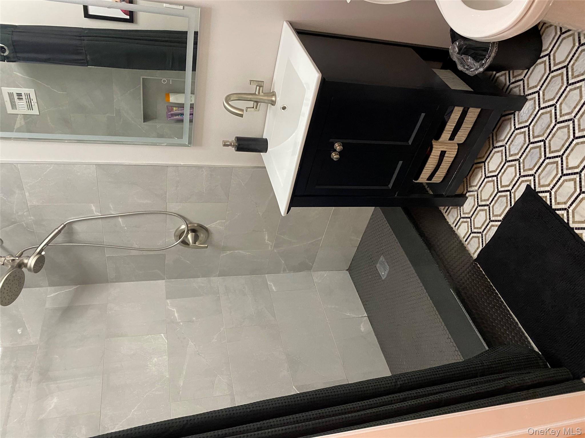 3 Hanover Square, Unit 12B Manhattan, NY 10004 - Photo 6 of 8 a bathroom with a sink a toilet a mirror and shower