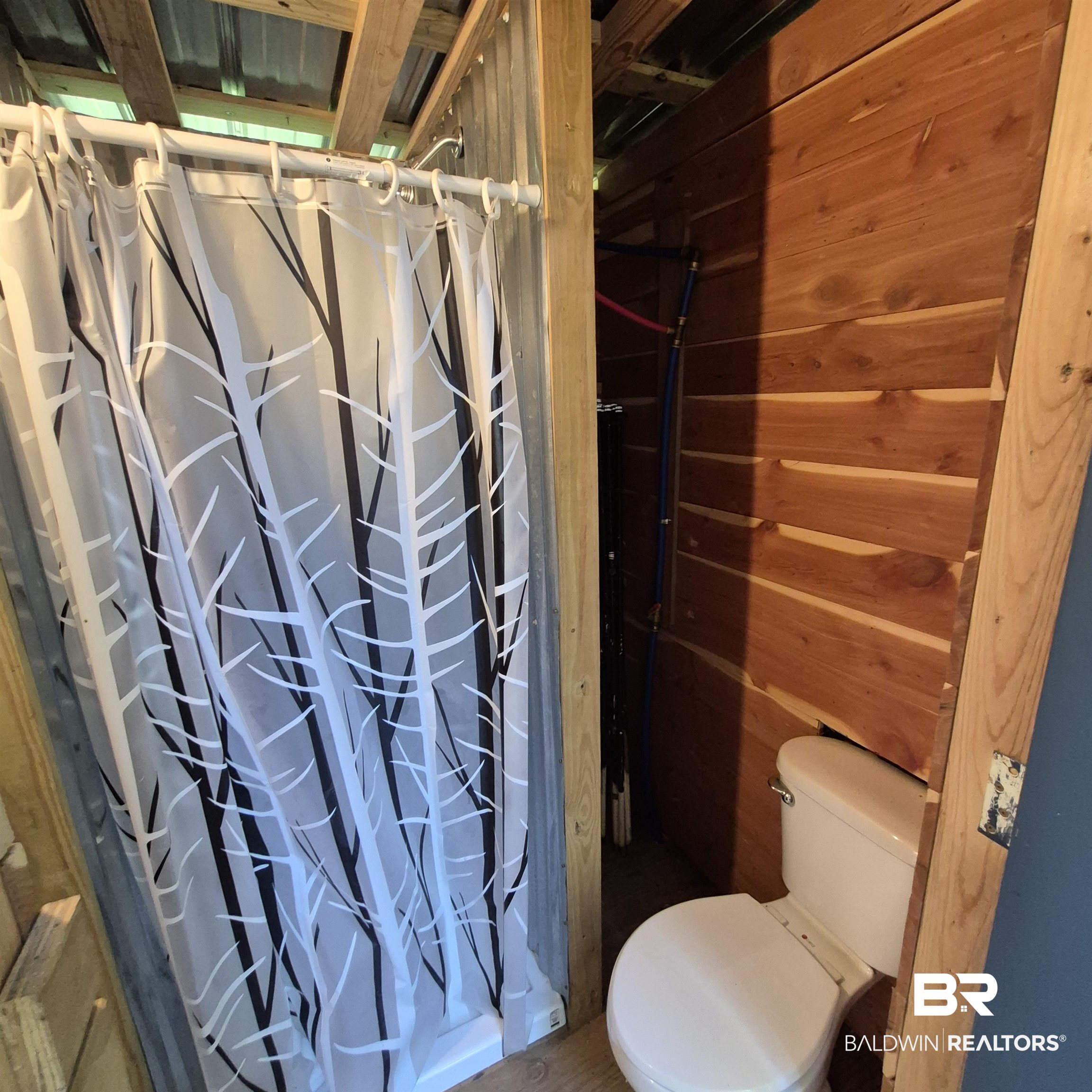 0 Eureka Landing Road Uriah, AL 36480 - Photo 14 of 27 Bathroom featuring a shower area with a patterned shower curtain, a white toilet, wood-plank walls, and exposed ceiling beams