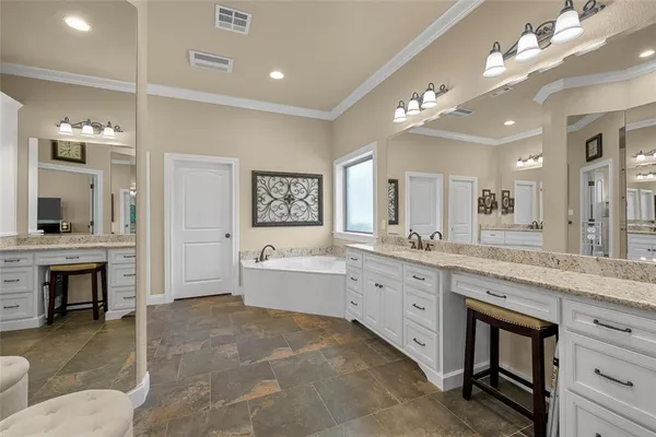 a spacious bathroom with a granite countertop sink mirror and bathtub