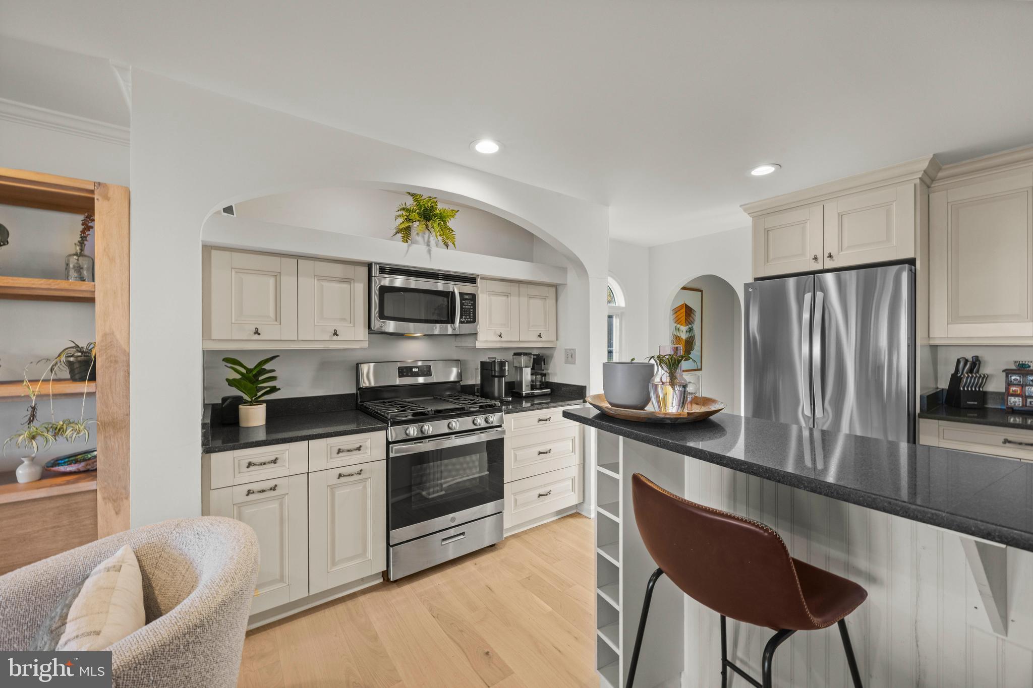 806 Monroe Manor Road Stevensville, MD 21619 - Photo 12 of 41 a kitchen with stainless steel appliances granite countertop a sink a stove a refrigerator cabinets and living room view