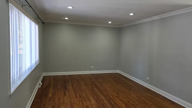 a view of a room with wooden floor and window