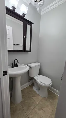 a bathroom with a toilet a sink and mirror