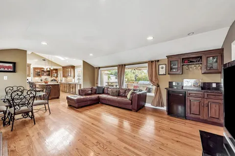 a living room with furniture and hard wood flooring