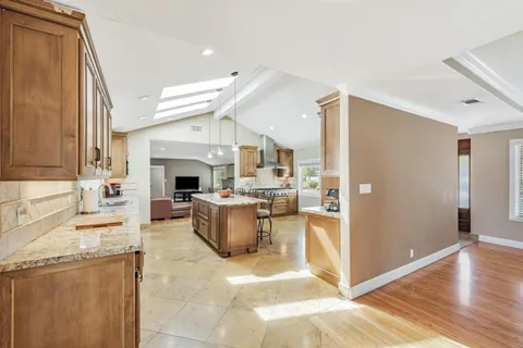 a living room with furniture a fireplace and a kitchen view