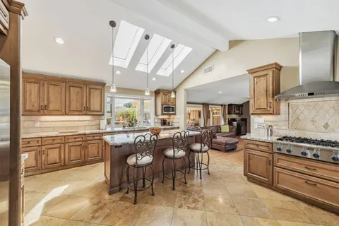 a kitchen with stainless steel appliances kitchen island granite countertop a sink and cabinets