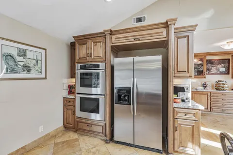 a kitchen with stainless steel appliances a refrigerator and a stove top oven