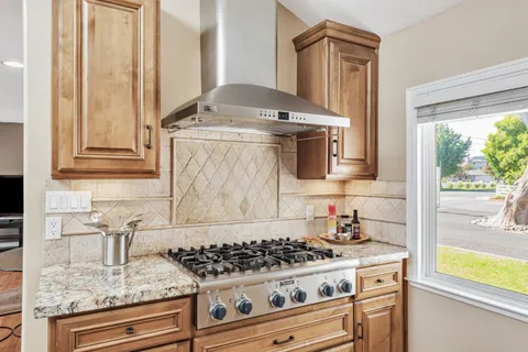 a kitchen with granite countertop a stove and a sink