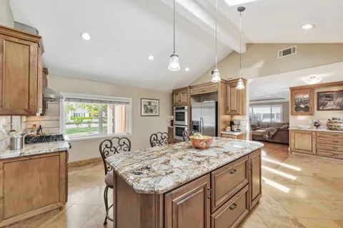 a open kitchen with stainless steel appliances granite countertop a sink a stove and a refrigerator