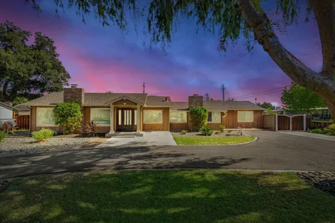 a view of a house with a yard and sitting area