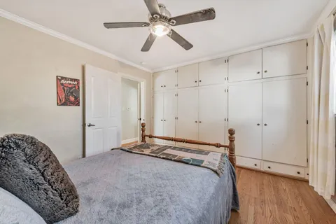 a bedroom with a bed and a chandelier fan