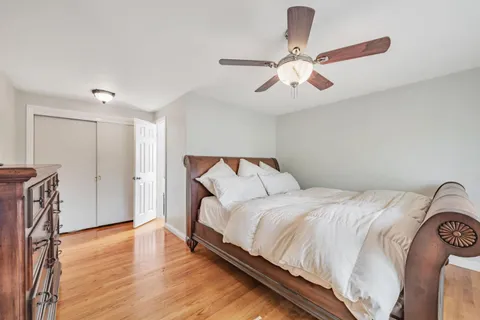 a bedroom with a bed and wooden floor