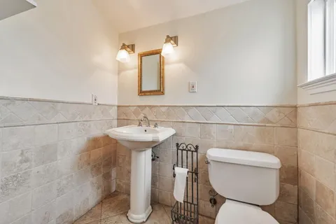 a bathroom with a toilet sink and mirror