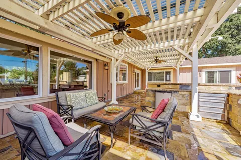a view of a patio with a dining table and chairs with wooden floor