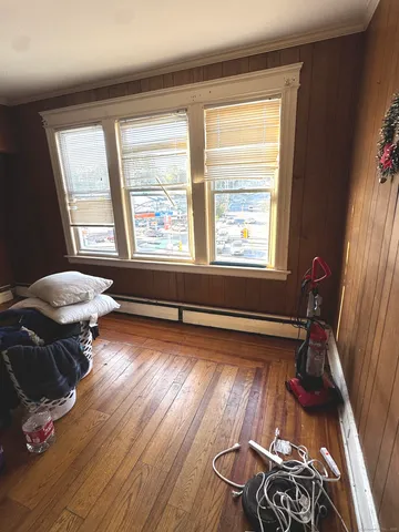 a view of a white house next to a yard with large trees