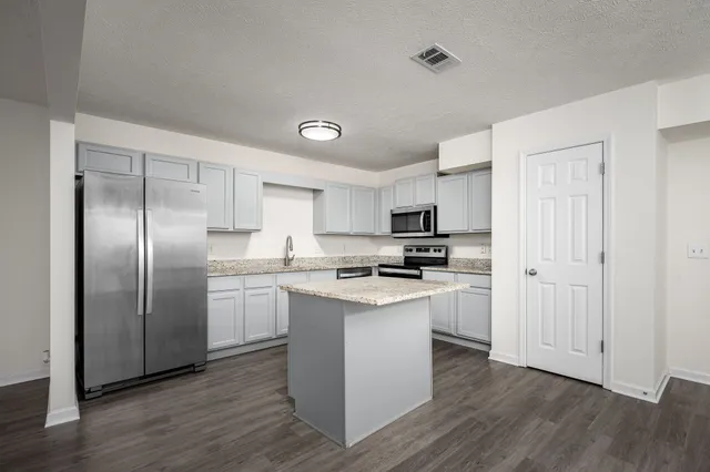 a kitchen with stainless steel appliances a refrigerator and a stove top oven