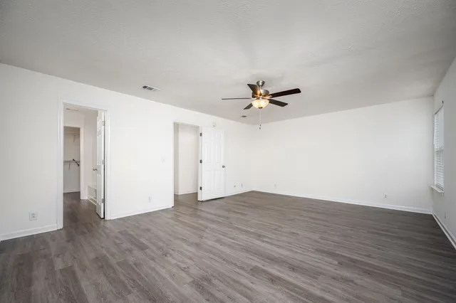 a view of an empty room with wooden floor