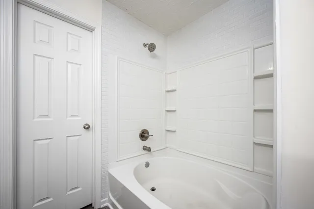 a white bath tub sitting next to a shower
