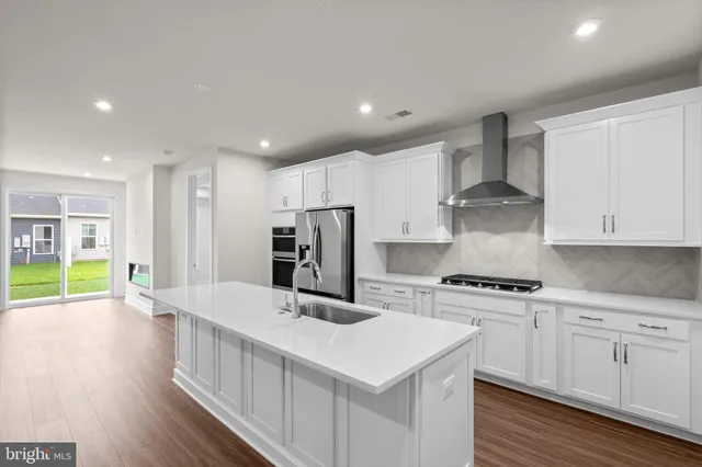 a kitchen with stainless steel appliances a white stove top oven and white cabinets