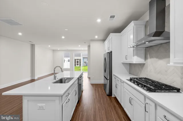 a kitchen with stainless steel appliances granite countertop a sink a stove and a refrigerator