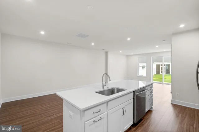 a kitchen with a sink cabinets and wooden floor
