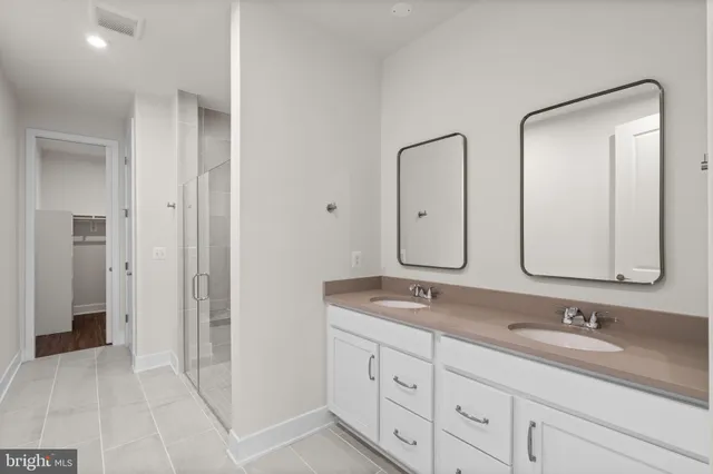 a bathroom with double vanity sinks and two mirror