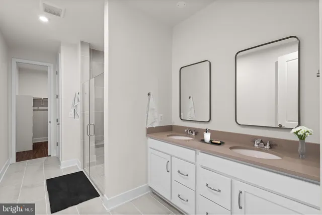 a bathroom with double vanity sinks and a mirror