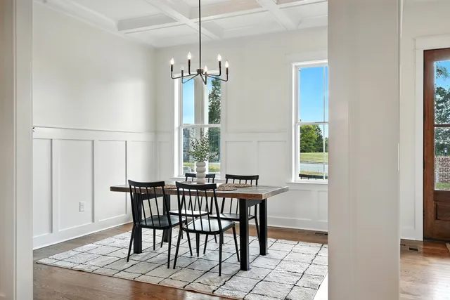 a dining room with wooden floor and a chandelier