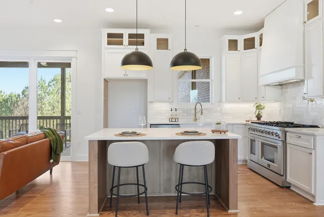 a kitchen with a sink a stove and chairs