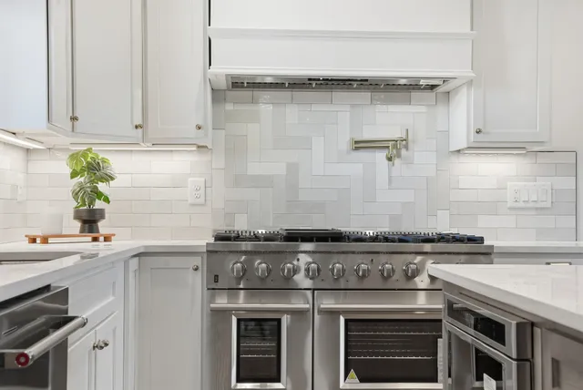 a kitchen with stainless steel appliances a sink stove and cabinets