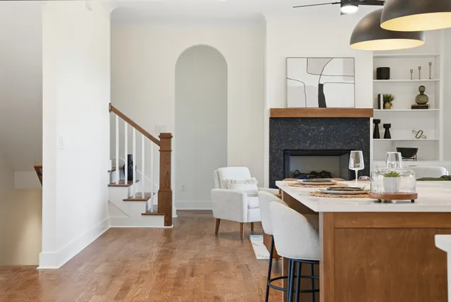 an empty room with wooden floor ceiling fan and windows