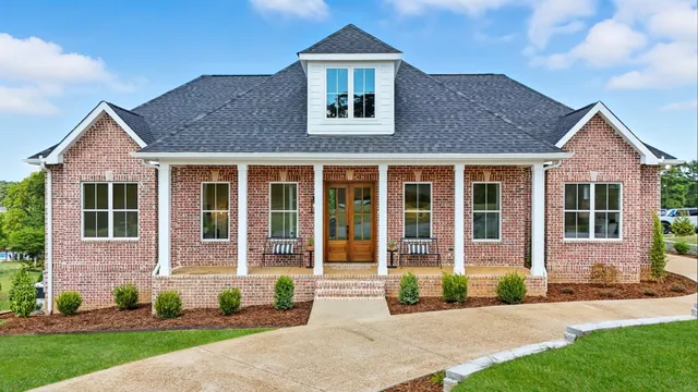 a front view of a house with a yard and outdoor seating