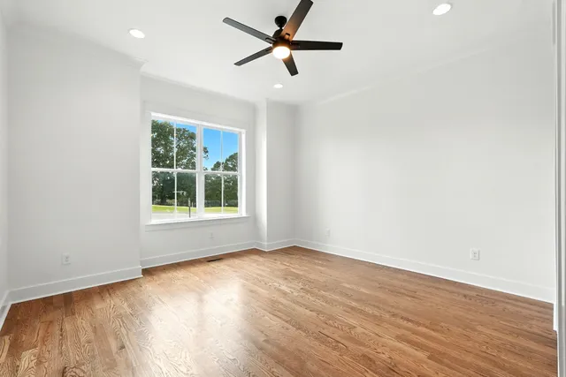 a view of empty room with wooden floor and window