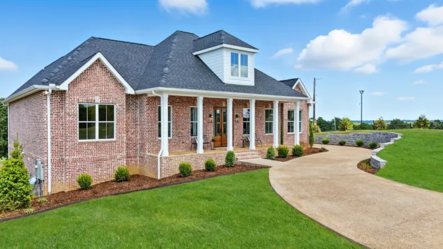 a front view of a house with yard and green space