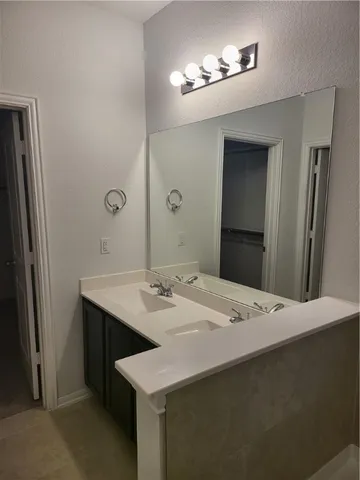 a hall with a sink and a mirror