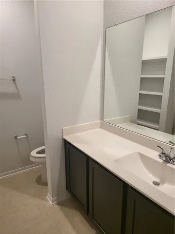 a bathroom with a sink a toilet and a mirror