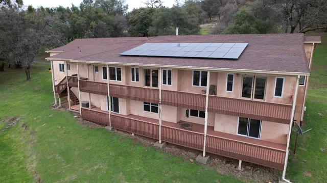 a kitchen with kitchen island granite countertop a sink a counter space appliances and cabinets