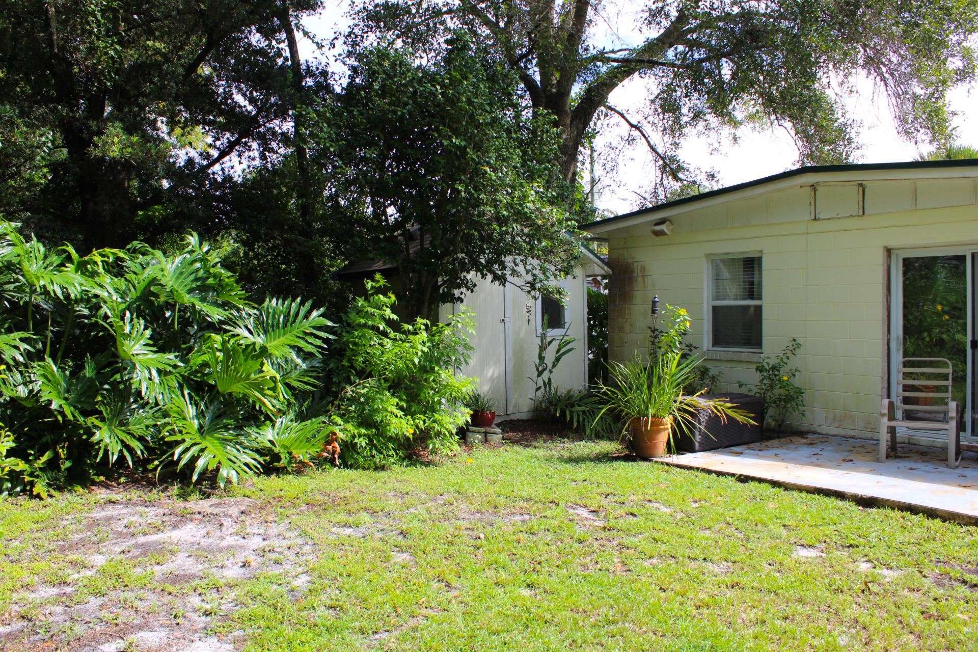248 Spring Street St. Augustine, FL 32084 - Photo 38 of 50 a backyard of a house with potted plants and large trees