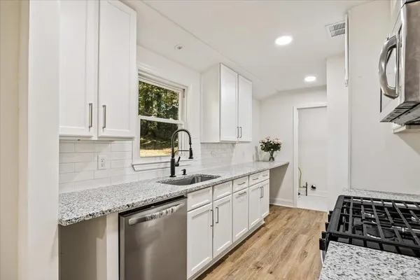 a kitchen with a sink stove and cabinets