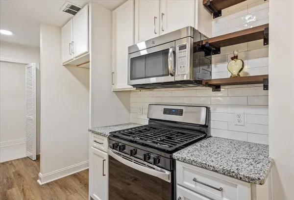 a stove top oven sitting inside of a kitchen