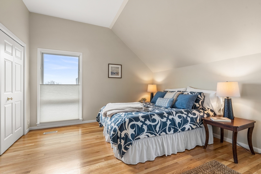 55 Brackett Place, Unit D Marblehead, MA 01945 - Photo 19 of 34 a bedroom with a bed and wooden floor