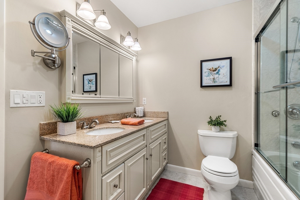 55 Brackett Place, Unit D Marblehead, MA 01945 - Photo 21 of 34 a bathroom with a sink a toilet and a mirror