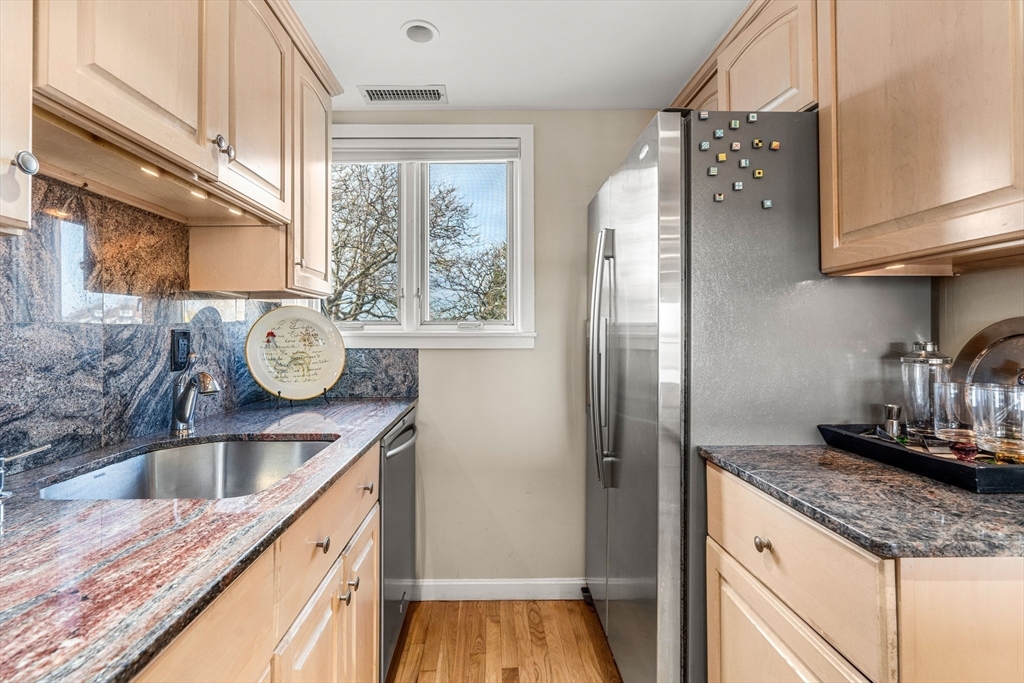 55 Brackett Place, Unit D Marblehead, MA 01945 - Photo 10 of 34 a kitchen with granite countertop a sink and a refrigerator
