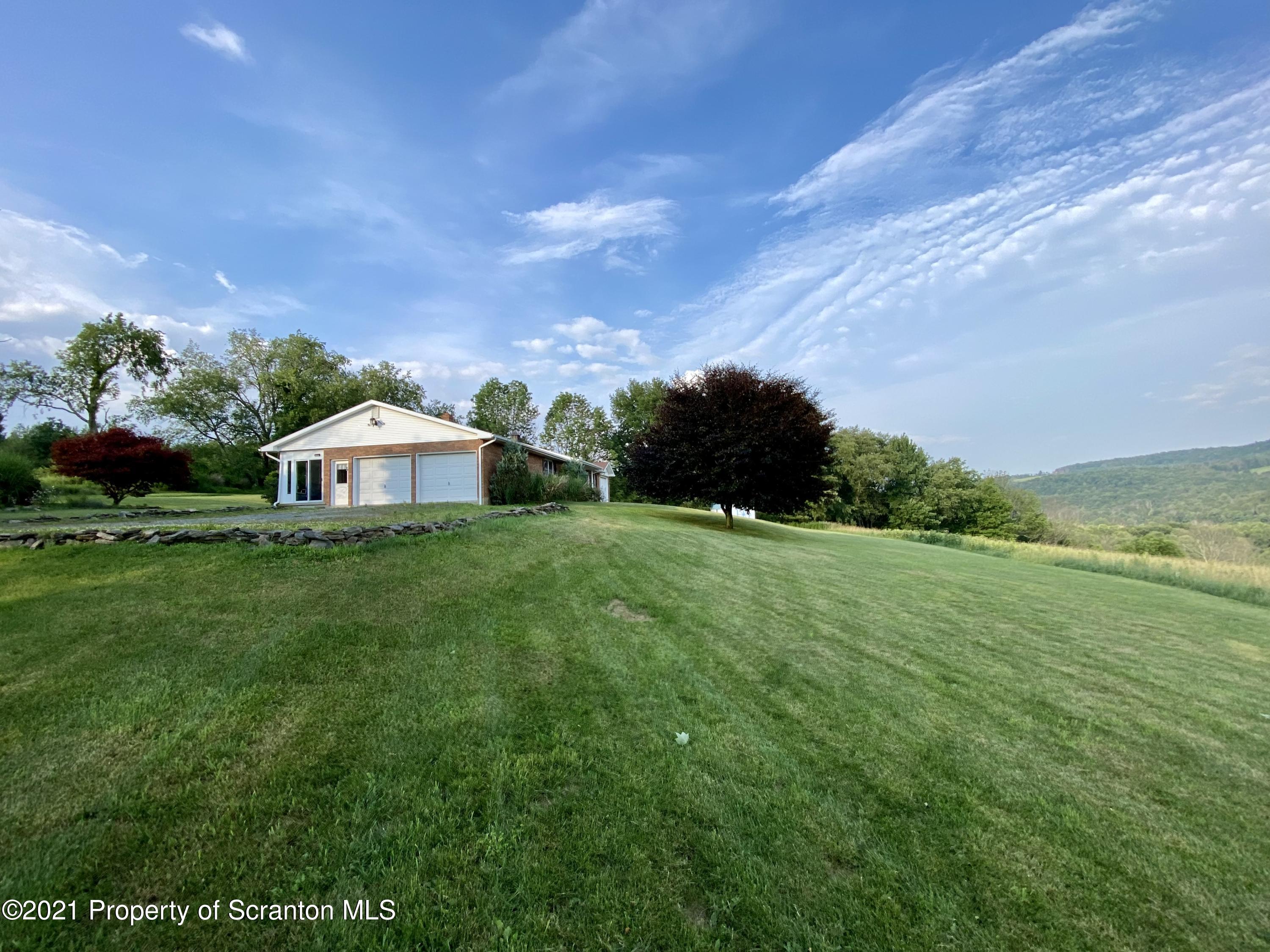 64 Thistle Hill Road Nicholson, PA 18446 - Photo 1 of 47 a view of a garden with a building in the background