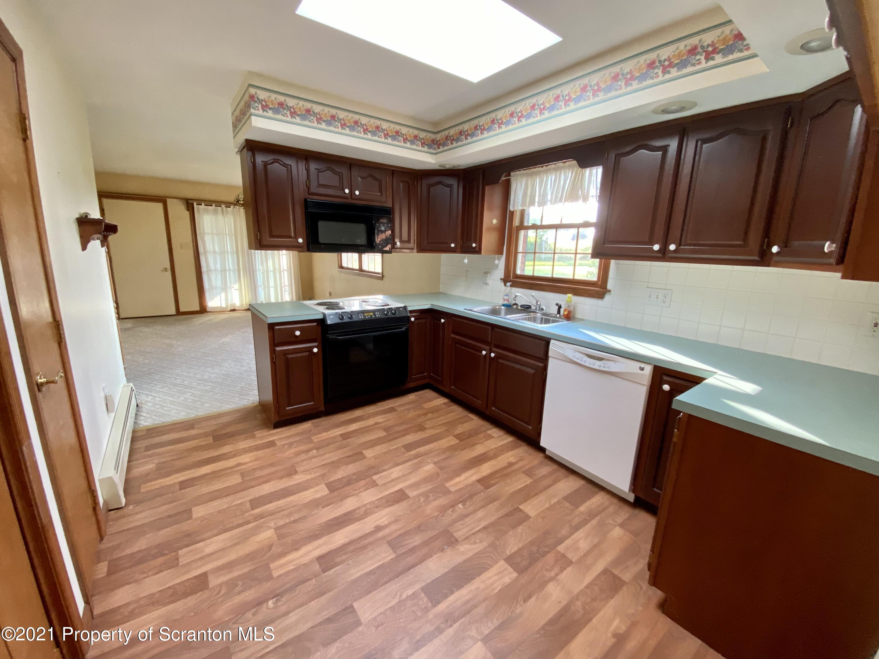 64 Thistle Hill Road Nicholson, PA 18446 - Photo 7 of 47 a large kitchen with stainless steel appliances granite countertop a sink and wooden cabinets