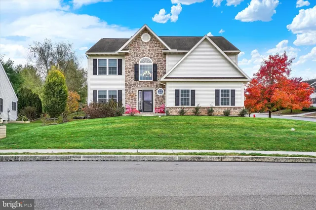 a front view of a house with a yard and trees