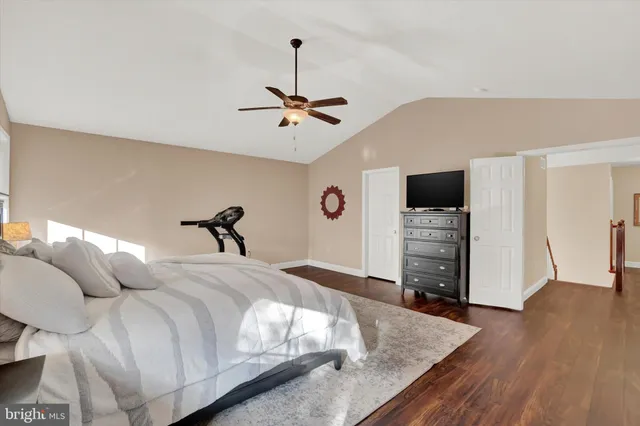 a spacious bedroom with a bed and a television