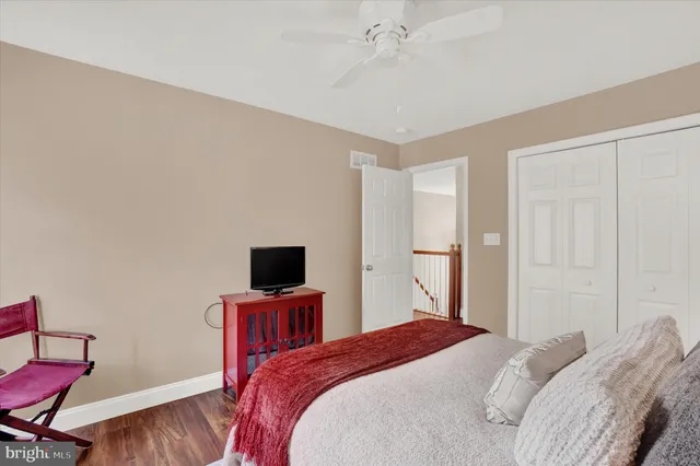 a bedroom with a bed window and a flat screen tv