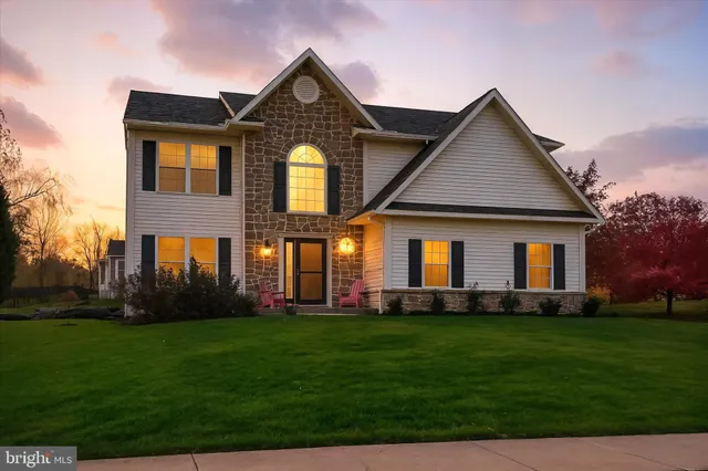 a front view of a house with a yard and green space